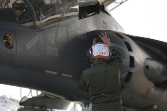 Lance Cpl. Viral Patel communicates with an TAV-8B Harrier crewmembers prior to take off at Marine Corps Air Station Cherry Point, N.C., March 11, 2016. A plane captain is responsible for conducting a final examination of the aircraft and guiding the pilots out onto the runway. Plane captains possess extensive knowledge of their designated aircraft and can determine if there are any last minute discrepancies that could potentially ground the aircraft. Patel is a plane captain and a fixed-wing aircraft mechanic with Marine Attack Training Squadron 203. (U.S. Marine Corps photo by Cpl. N.W. Huertas/Released)
