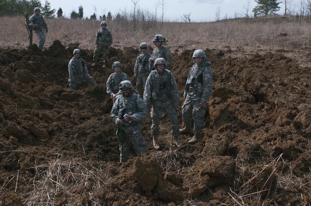 Digging yourself a hole - U.S. Army Reserve Soldiers with the 450th Engineer Company stand in a crater created by their demolition operations during the 478th Engineer Battalion's crew-served weapons qualification and field training exercise, March 10 to 13 at Fort Knox, Ky. (U.S. Army photo by Staff Sgt. Debralee Best)