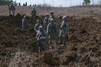Digging yourself a hole - U.S. Army Reserve Soldiers with the 450th Engineer Company stand in a crater created by their demolition operations during the 478th Engineer Battalion's crew-served weapons qualification and field training exercise, March 10 to 13 at Fort Knox, Ky. (U.S. Army photo by Staff Sgt. Debralee Best)