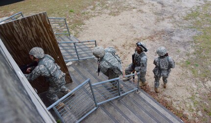 Sgt. Wayne Jones a team leader from Gainesville, Ga., representing the from 642nd Regional Support Group based in Decatur Ga., listens for the verbal cue as his team prepares to clear a building, which was one of the many events conducted at the 143rd ESC’s Best Warrior Competition conducted March 14-18, 2016, at Camp Blanding, Fla.