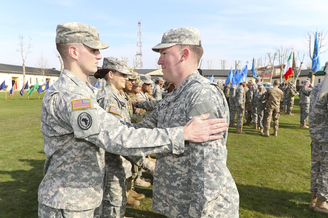 Military Intelligence Soldiers place new unit patches on one another during the activation ceremony of 207th Military Intelligence Brigade March 16, 2016 here at Hoekstra Field at Caserma Ederle. The 207th MI Bde. will serve as the Theater Intelligence Brigade for U.S. Africa Command and is under operational control of U.S. Army Africa. The brigade includes the 207th MI Bde. Headquarters and 307th MI Battalion located here, as well as the 522nd MI Battalion located at Wiesbaden, Germany, and the 337th MI Battalion located at Fort Sheridan, Ill. (U.S. Army Africa photo by Staff Sgt. Lance Pounds)