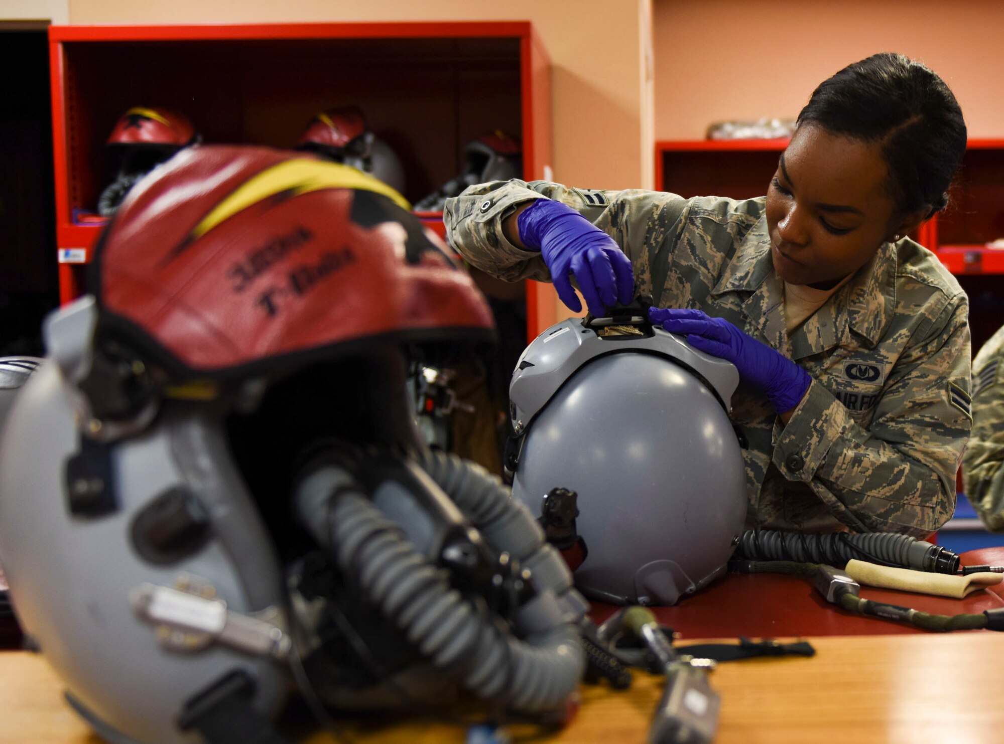 Airman 1st Class Kayla Stennis, 366th Operations Support Squadron aircrew flight equipment journeyman, adjusts pilots' helmets before takeoff at Mountain Home Air Force Base, Idaho, March 14, 2016. The helmets must be thoroughly inspected and in perfect condition before use. (U.S. Air Force photo by Airman Alaysia Berry/RELEASED)
