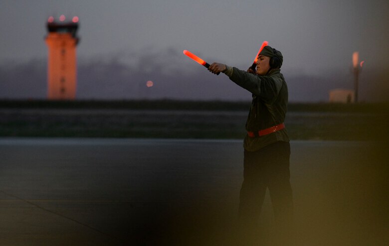 An airman motions for an F-15E Strike Eagle to prepare for taxiing at Mountain Home Air Force Base, Idaho, March 15, 2016. The 366th Operations Group and 366th Maintenance Group conducted 24-hour operations during a 72-hour sortie surge.(U.S. Air Force photo by Airman 1st Class Jessica H. Evans/RELEASED)