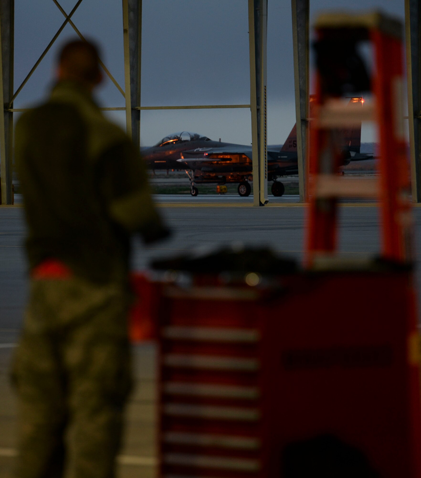An airmen looks out at an F-15E Strike Eagle as it begins it's taxi in preparation for take-off at Mountain Home Air Force Base, Idaho, March 15, 2016. F-15Es flew sorties throughout all hours of the day as part of a 72-hour sortie surge. (U.S. Air Force photo by Airman 1st Class Jessica H. Evans/RELEASED)