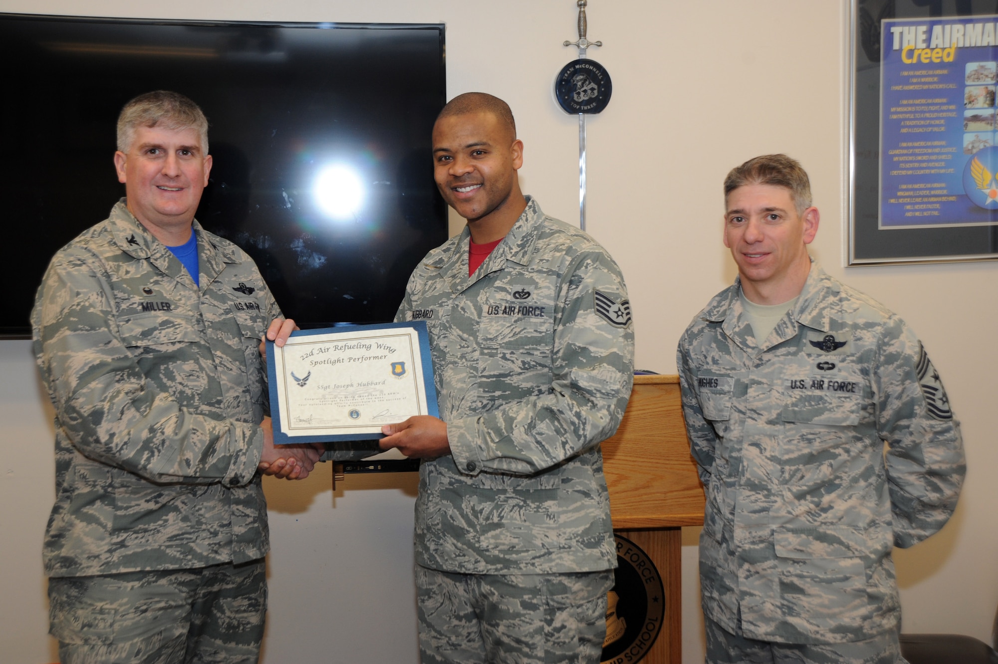 Staff Sgt. Joseph Hubbard, 22nd Force Support Squadron professional military education instructor, poses with Col. Albert Miller, 22nd Air Refueling Wing commander, and Chief Master Sgt. Shawn Hughes, 22nd ARW command chief, March 11, 2016, at McConnell Air Force Base, Kan. Hubbard received the spotlight performer for the week of Feb. 29 – March 4. (U.S. Air Force photo/Airman Jenna Caldwell)