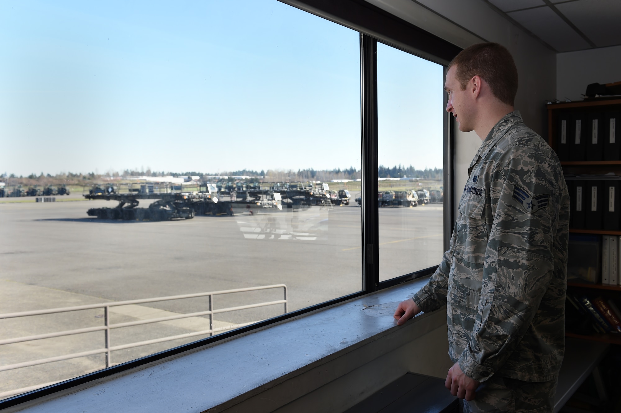 Senior Airman Brandon Cargill, 62nd Aerial Port Squadron ramp services journeyman, looks out of his office window in the ramp services section of the 62nd APS March 17, 2016, at Joint Base Lewis-McChord, Wash. The ramp services section of the APS provides eyes on the aircraft flying to and from McChord Field by ensuring whatever is on the plane is safe to fly and meets requirements. (U.S. Air Force photo/Staff Sgt. Naomi Shipley)