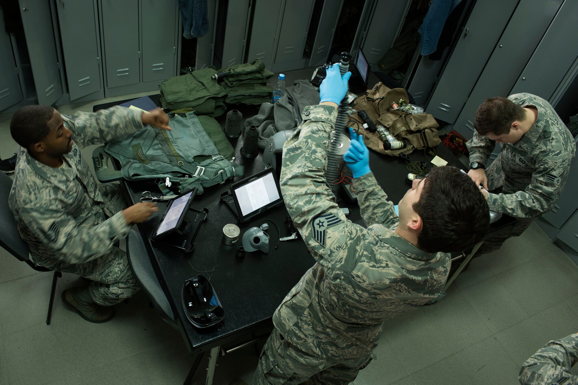 U.S. Air Force Tech. Sgt. Nathanial Robinson Jr., left, Staff Sgt. Kevin Ray, center, and Senior Airman Ian Sinchak, right, all 74th Expeditionary Fighter Squadron aircrew flight equipment technicians from the 23rd Operations Support Squadron at Moody Air Force Base, Ga., inspect, repair and prepare flight equipment during the 74th EFS’s deployment in support of Operation Atlantic Resolve at Graf Ignatievo, Bulgaria, March 16, 2016. The technicians ensure a full spectrum of survivability of air crew for in-flight, flight ejection and land survival scenarios. (U.S. Air Force photo by Staff Sgt. Joe W. McFadden/Released)