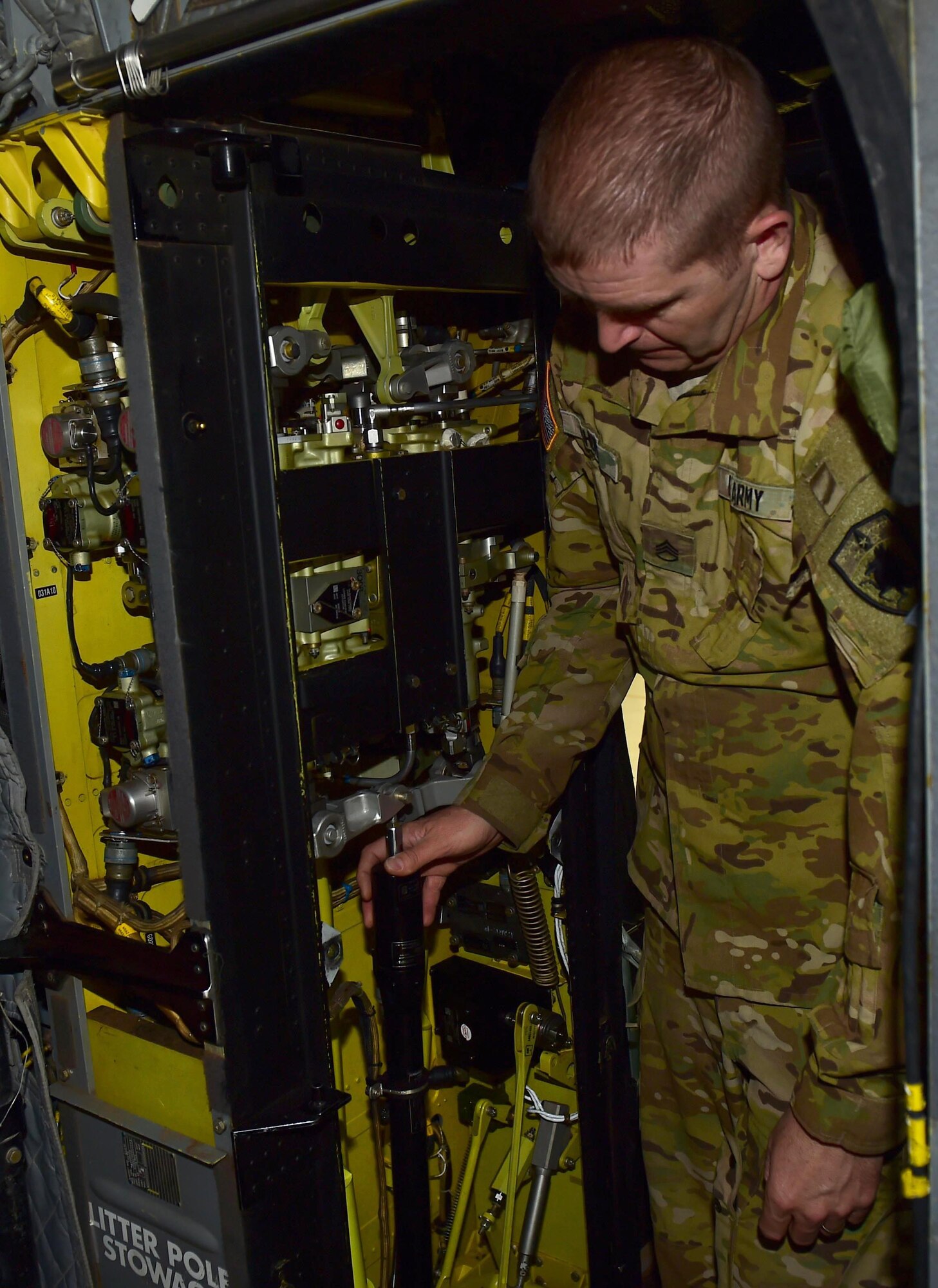 U.S. Army Staff Sgt. Wade Shore, Colorado Army National Guard CH-47 crew chief, displays the parts inside the utility panel behind the helicopter pilots’ seats March 3, 2016, at the Army Aviation Support Facility on Buckley Air Force Base, Colo. A crew chief ensures that the utility panel is working correctly before, after and during a flight. (U.S. Air Force photo by Airman 1st Class Gabrielle Spradling/Released)