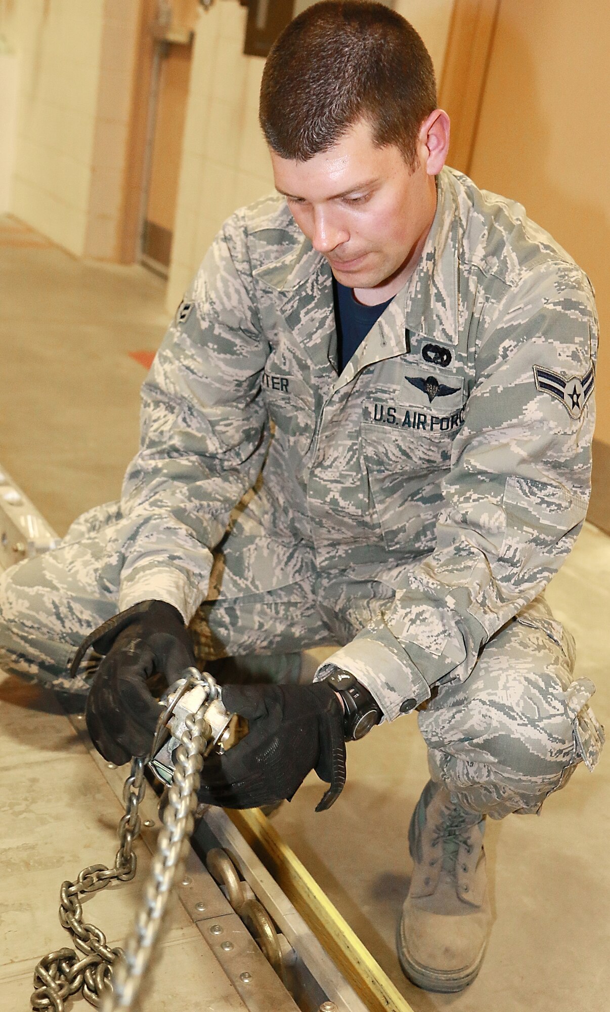 Airman 1st Class Brett Ritter, an air transportation rigger with the 58th Operations Support Squadron, practices securing a chain to a device for securing cargo to a heavy pallet, during Phase III of the Aerial Port Night Vision Course on March 11 at Kirtland Air Force Base, New Mexico. Phase III of the training includes uploading/downloading cargo In a real world no-light/low-light environment on an aircraft with the engines running. (U.S. Air Force photo by Master Sgt. Phyllis Keith)
