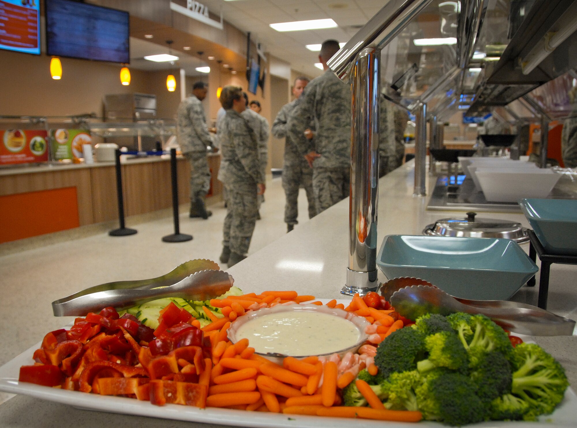 Airmen gather at the Breeze Dining Facility following the Food Transformation Initiative graduation ceremony March 18.  Approximately 35 Airmen completed the course and will be serving when the Breeze reopens March 24.  FTI promotes healthy eating in the military.  (U.S. Air Force photo/Kevin Gaddie)