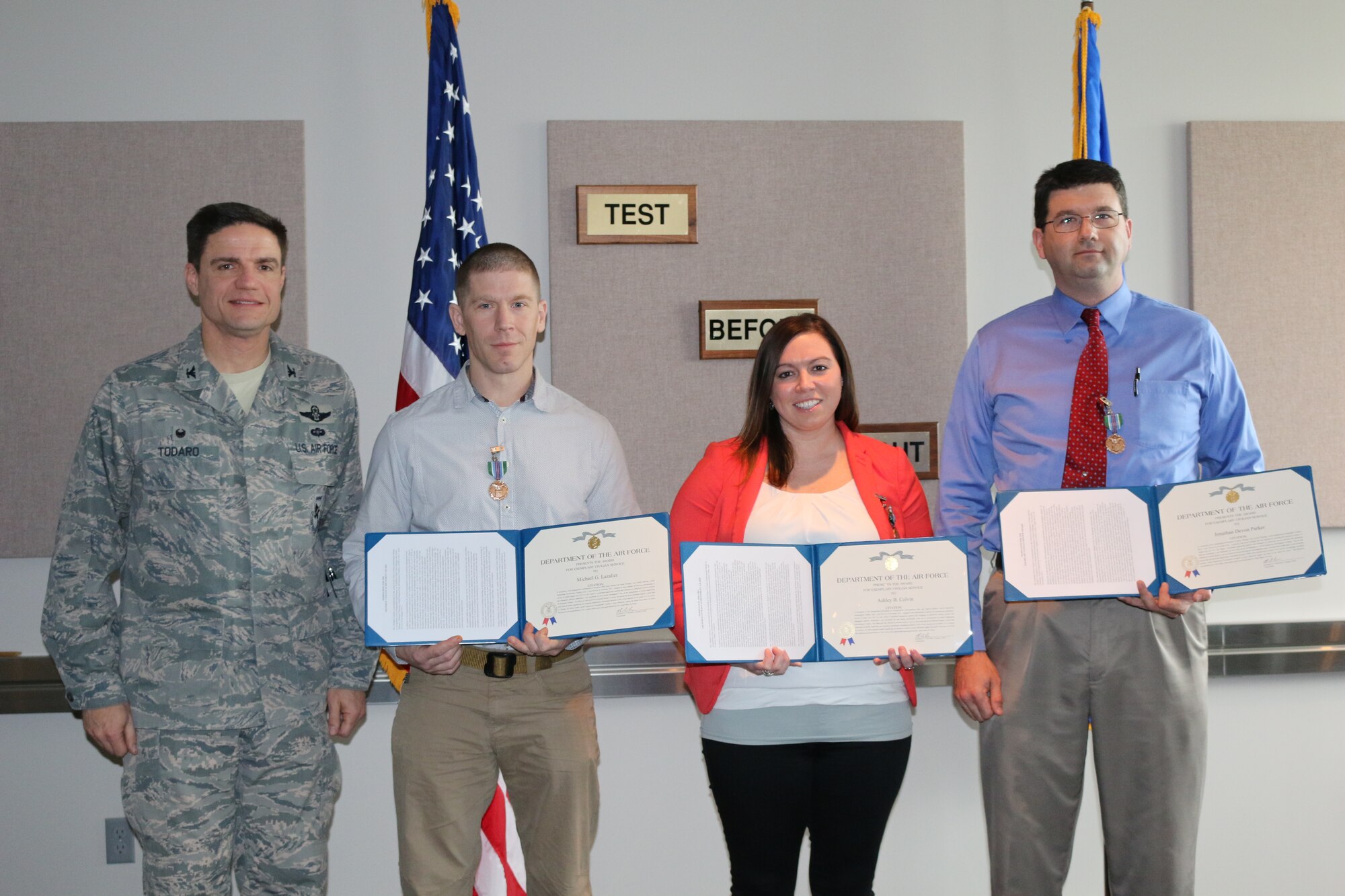 AEDC Commander Col. Rodney Todaro (left) presents the Exemplary Civilian Service Award to the T-11 Test Facility Return-to-Service Team who includes left to right, Michael Lazalier, Propulsion Plant Asset manager; Ashley Colvin, Aeropropulsion Instrumentation, Data and Controls engineer; and Devon Parker, senior manager with Test Facility Planning. The award, presented Feb. 15, 2016, at AEDC, was to recognize the engineering leadership of an integrated Air Force and ATA team during the restoration of the Engine Test Facility test cell T-11 at less than 15 percent of the estimated cost. (U.S. Air Force photo/Holly Fowler)