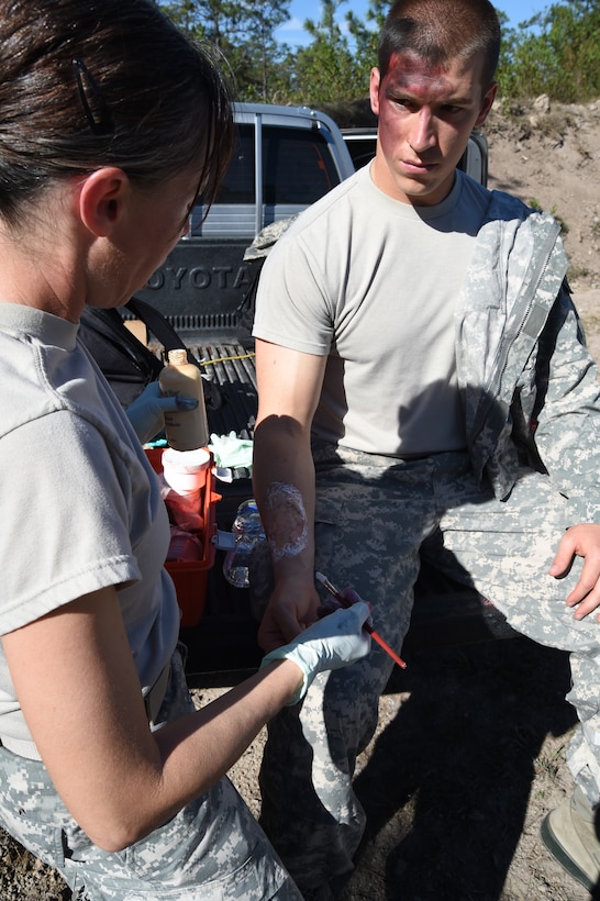 Staff Sgt. Yanna Ramaekers (left), Joint Task Force-Bravo Medical Element medic, applies simulated wounds, or moulage, on 1Lt. Andrew Lankow, Joint Task Force-Bravo Ports and Plans officer in charge, March 10, 2016 near Soto Cano Air Base, Honduras, for a simulated personnel recovery exercise. 1Lt. Lankow played a UH-60 Black Hawk helicopter crash victim for this exercise which involved both Honduran forces and Servicemembers from JTF-Bravo. (U.S. Army photo by Martin Chahin/Released)