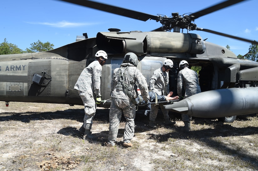 Airmen from Joint Task Force-Bravo 612th Air Base Squadron Fire Department practice loading a simulated crash victim onto a U.S. Army UH-60 Black Hawk helicopter during a personnel recovery exercise, March 10, 2016, near Soto Cano Air Base, Honduras. This was the first participation of firefighters during JTF-Bravo’s quarterly personnel rescue practices, testing their abilities to respond to this type of mission. (U.S. Army photo by Martin Chahin/Released)