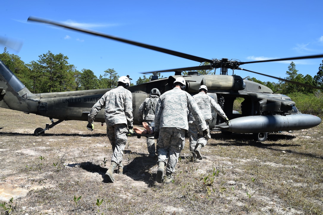 Airmen from Joint Task Force-Bravo 612th Air Base Squadron Fire Department practice loading a simulated crash victim onto a U.S. Army UH-60 Black Hawk helicopter during a personnel recovery exercise, March 10, 2016, near Soto Cano Air Base, Honduras. This was the first participation of firefighters during JTF-Bravo’s quarterly personnel rescue practices, testing their abilities to respond to this type of mission. (U.S. Army photo by Martin Chahin/Released)