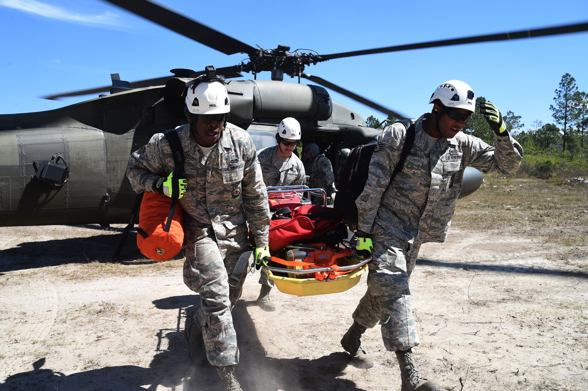 Airmen with Joint Task Force-Bravo 612th Air Base Squadron Fire Department, practice unloading rescue equipment from a U.S Army UH-60 Black Hawk helicopter during a simulated personnel recovery exercise, March 10, 2016 near Soto Cano Air Base, Honduras. The Fire Department supported the exercise with their extrication capabilities and equipment, testing their ability to respond to a personnel recovery mission. (U.S. Army photo by Martin Chahin/Released)
