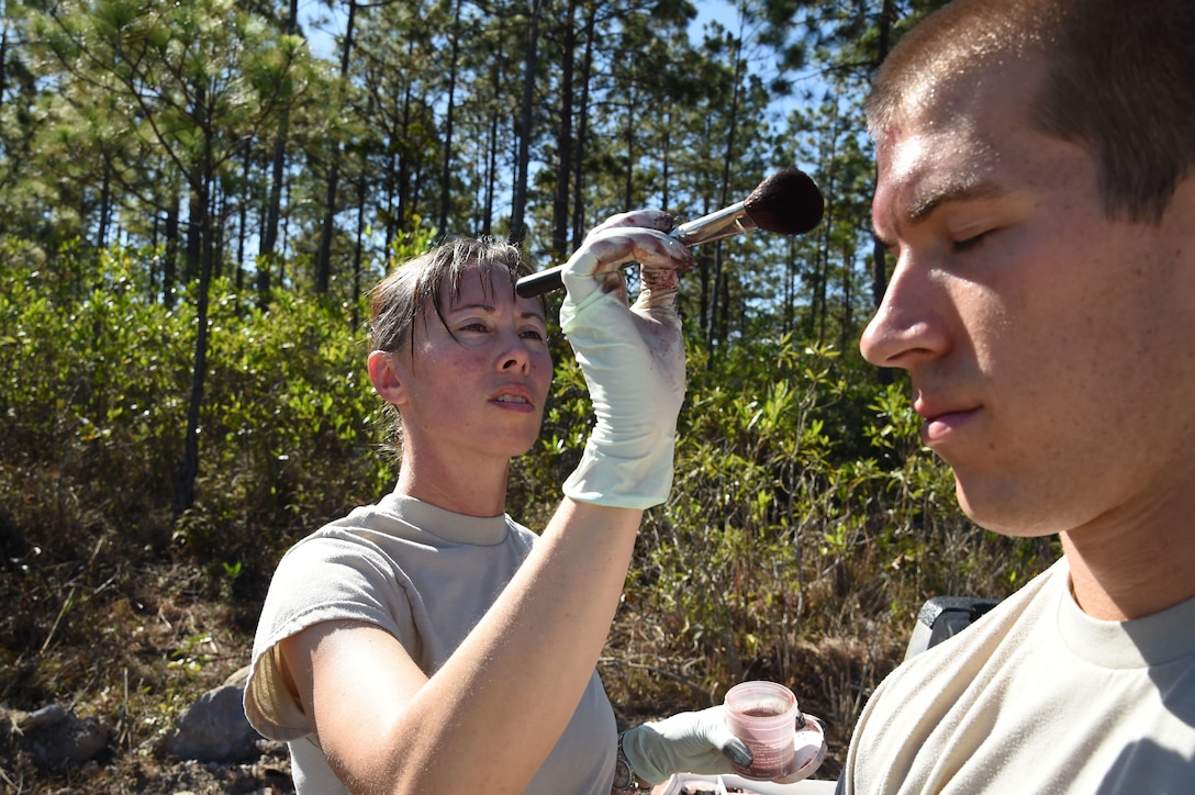 Staff Sgt. Yanna Ramaekers (left), Joint Task Force-Bravo Medical Element medic, applies simulated wounds, or moulage, on 1Lt. Andrew Lankow, Joint Task Force-Bravo Ports and Plans officer in charge, March 10, 2016 near Soto Cano Air Base, Honduras, for a simulated personnel recovery exercise. 1Lt. Lankow played a UH-60 Black Hawk helicopter crash victim for this exercise which involved both Honduran forces and Servicemembers from JTF-Bravo. (U.S. Army photo by Martin Chahin/Released)