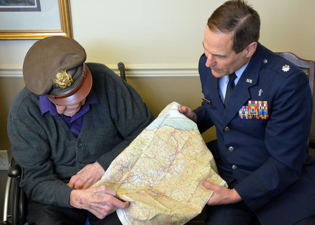 Retired World War II navigator Lt. Col. Leonard Erickson shows 120th Airlift Wing Chaplain, Lt. Col. Arthur McCaffrey, his silk survival map of Holland, Belgium, France and Germany during a visit to an assisted living facility in Butte, Mont., March 10, 2016. (U.S. Air National Guard photo by Senior Master Sgt. Eric Peterson/Released)