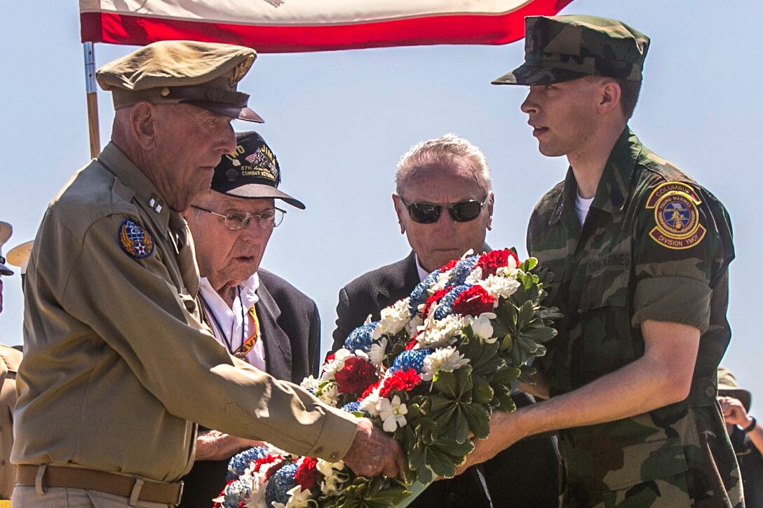 Former Army Air Corps Capt. Jerry Yellin, left, Navy Seabee Jack Lazere, center left, and Marine Carl DeHaven, veterans of the Battle of Iwo Jima, accept a wreath from a member of the Young Marines group during the 71st Reunion of Honor Ceremony at Iwo To, Japan, March 19, 2016. The ceremony gathers surviving veterans, their families and active duty service members of both nations to reflect on 71 years of peace and prosperity between the U.S. and Japan alliance. Marine Corps photo by Cpl. Robert Williams Jr.