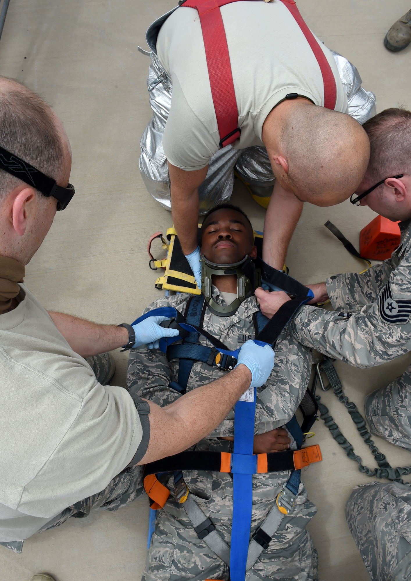 Senior Airman Jerome Llanes, 5th Expeditionary Aircraft Maintenance Squadron C-17 communications navigation systems technician, raises a B-1 stand to support a mock casualty during a fall protection exercise on the flightline at an undisclosed location in Southwest Asia, March 14, 2016. A fall protection plan is required at any work site where there is a potential for a member to fall from a high elevation. (U.S. Air Force photo by Staff Sgt. Jerilyn Quintanilla)