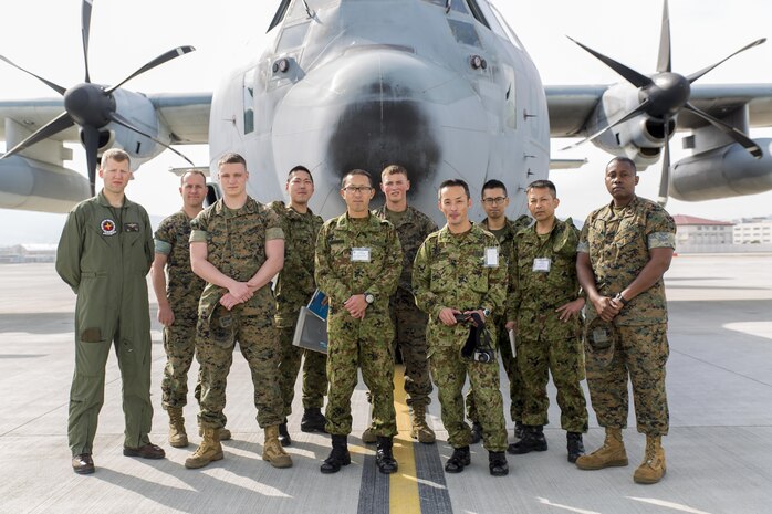 Japan Ground Self-Defense Force interpreter trainees and instructors, and their Marine English instructors pose for a group photo with KCJ-130 Super Hercules with Marine Aerial Refueler Transport Squadron 152 during the Public Affairs Office’s annual English seminar on Marine Corps Air Station Iwakuni, Japan, March 16, 2016. The seminar is held annually by the station Public Affairs Office to help improve upon the JGSDF’s understanding and use of the English language prior to their deployment in support of exercises in both the United States and Japan.  (U.S. Marine Corps photo by Sgt. Antonio J. Rubio/Released)