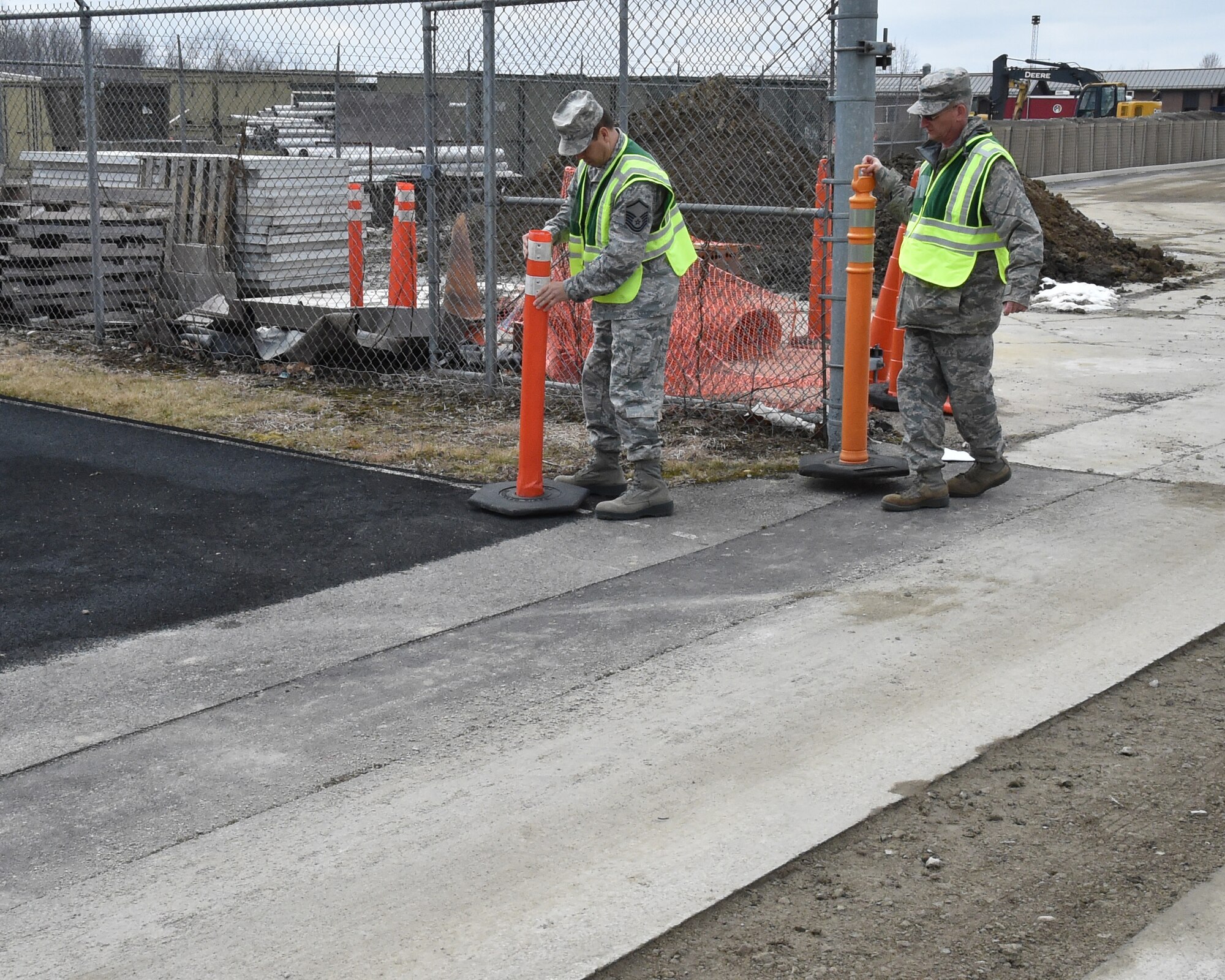 Master Sgt. Craig White, noncommissioned officer in charge of occupational safety and Technical Sgt. Mike Riggenbach, an occupational ground safety technician, place warning cones on the fitness track where construction has made the track hazardous here, March 6, 2016. White and Riggenbach are both assigned to the 910th Safety Office and are responsible for all elements of ground safety at the 910th Airlift Wing. (U.S. Air Force Reserve Photo/ Tech. Sgt. Rick Lisum)
