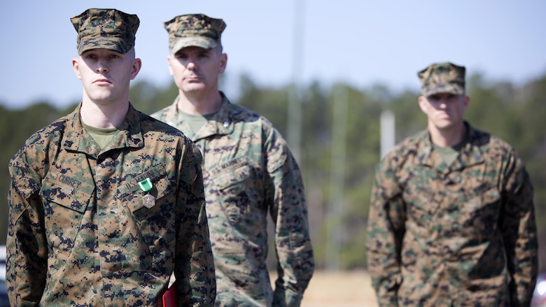 Cpl. Joseph Currey, left, stands in front of Lt. Col. Jeremy Winters , center, and Sgt. Maj. Jeffrey Durham after receiving an award at Marine Corps Air Station Cherry Point, North Carolina, March 1, 2016. Currey was awarded the Navy and Marine Corps Commendation Medal for his actions after witnessing an ambulance wreck. Currey demonstrated his devotion to serving others as he placed the well-being of the injured personnel above his own by running towards the scene of an accident and rendering aide to those need. Currey is an air support operations operator with Marine Aviation Support Squadron 1. Winters is the commanding officer of the squadron and Dunham is the squadron sergeant major.