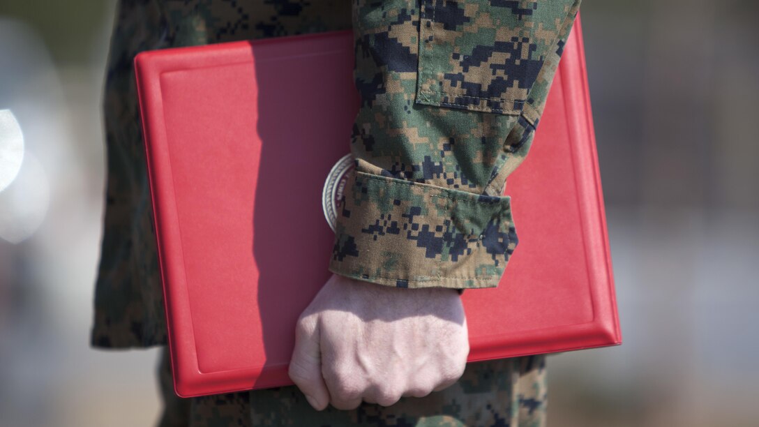 Cpl. Joseph Currey grips his award during an award ceremony at Marine Corps Air Station Cherry Point, North Carolina, March 1, 2016. Currey was awarded the Navy and Marine Corps Commendation Medal for his actions after witnessing an ambulance wreck. Currey demonstrated his devotion to serving others as he placed the well-being of the injured personnel above his own by running towards the scene of an accident and rendering aide to those need. Currey is an air support operations operator with Marine Aviation Support Squadron 1.