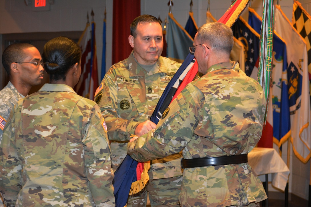 Command Sgt. Maj. Arlindo Almeida, outgoing senior noncommissioned officer of the 94th Training Division, hands the command colors to Brig. Gen. Steven W. Ainsworth, the 94th TD commander, symbolizing Almeida’s relinquishment of his duties. The change of responsibility took place during a ceremony at Fort Lee, Va., March 18, 2016. Ainsworth then passed the colors to Command Sgt. Maj. Sharon Campbell, making her the 94th TD’s new senior noncommissioned officer. Campbell is now the first female to hold the senior NCO position at the 94th TD.