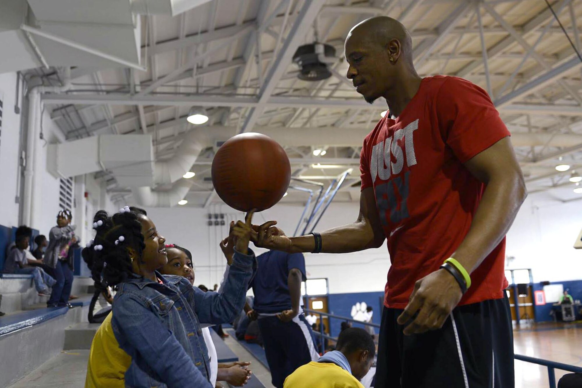 Damien Coley (right), a Goldsboro, North Carolina native, teaches local children to spin a basketball on their finger in between basketball games, March 19, 2016, at Dillard Middle School in Goldsboro. The Wayne County community and Team Seymour members formed teams of six to participate in the tournament and strengthen community relations. (U.S. Air Force photo/Airman 1st Class Ashley Williamson)