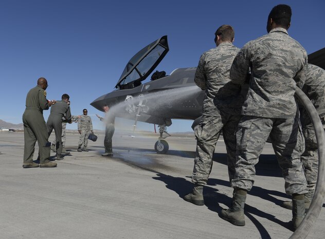 Maj. Gen. Silveria, United States Air Force Warfare Center commander, is showered with a fire hose after his final flight at Nellis Air Force Base, Nev., March 10, 2016. As a pilot retires or leaves a squadron, the last flight in the aircraft is known as a fini flight. (U.S. Air Force photo by Airman 1st Class Nathan Byrnes)