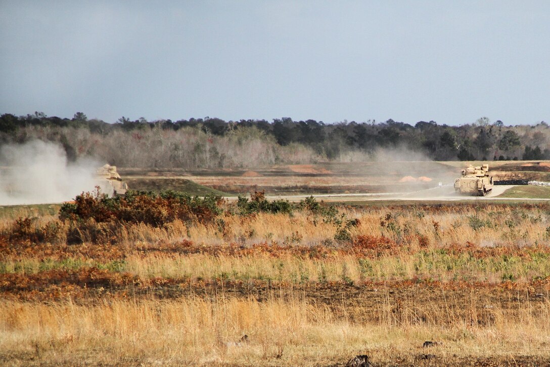 Two M3A3 Bradley fighting vehicles maneuver into position to fire their M242 25mm Bushmaster chain guns during a live-fire training exercise at Fort Stewart, Ga., March 10, 2016. Army photo by Pfc. Payton Wilson