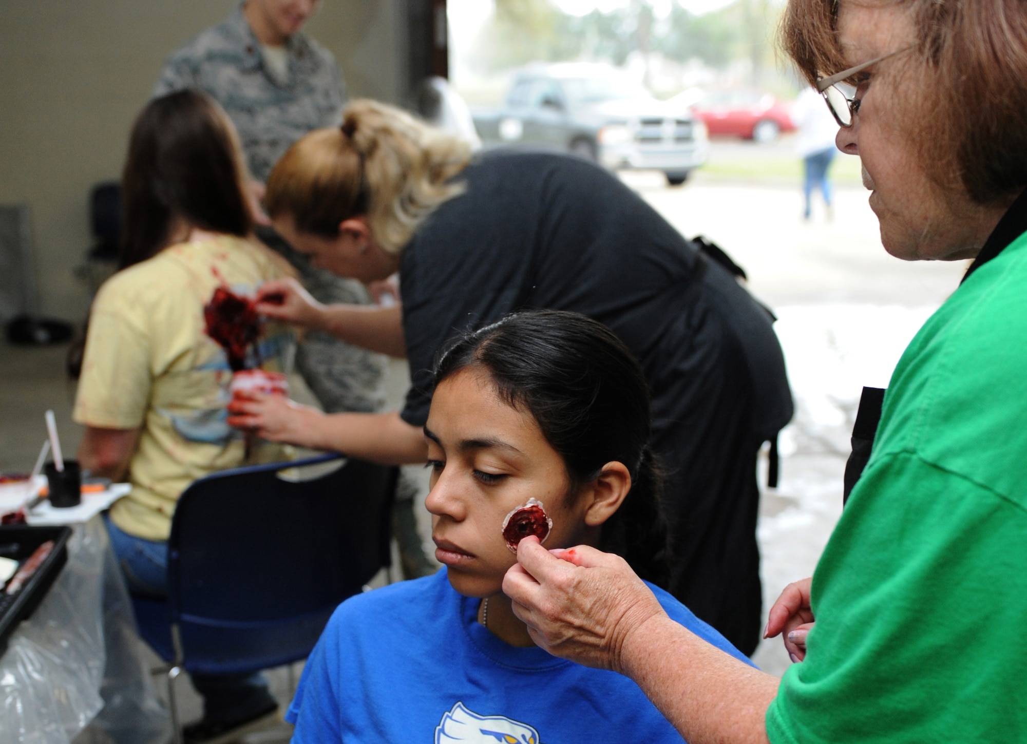 Regina Parker, 81st Medical Operations Squadron administrator, applies moulage to Airman 1st Class Lupita Lopez, 81st Inpatient Operation Squadron medical technician, at the Keesler medical warehouse Mar. 17, 2016, Keesler Air Force Base, Miss. Lopez portrayed a wounded person during a base active shooter exercise where an active duty Air Force member simulated opening fire at the Keesler Medical Center. The exercise tested the base's ability to respond to and recover from a mass casualty event. (U.S. Air Force photo by Kemberly Groue)