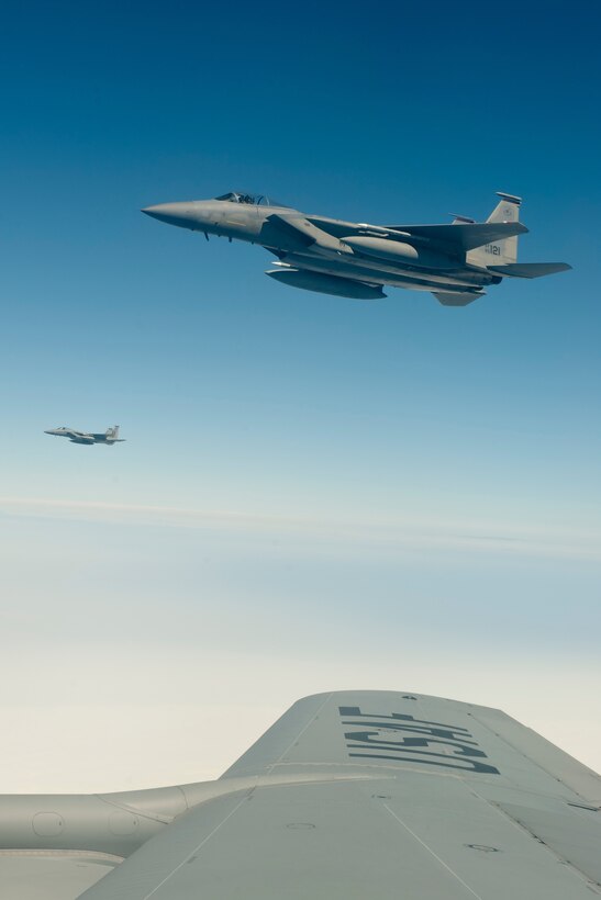 Two U.S. Air Force F-15C Eagle aircraft with the 44th Fighter Squadron fly in formation with a KC-135 Stratotanker from the 909th Air Refueling Squadron, March 21, 2016, off the coast of Japan. The 44th FS and 909th ARS conducted an inflight refueling exercise to demonstrate their capability for long-range flight operations with tanker support. (U.S. Air Force photo by Senior Airman Peter Reft/Released)