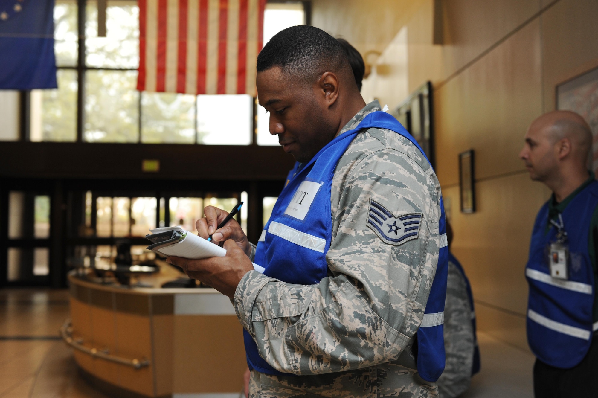 Staff Sgt. Detrick Jack, 81st Security Forces Squadron standardization evaluations NCO in charge and Wing Inspection Team member, takes notes during Keesler's active shooter exercise at the Keesler Medical Center Mar. 17, 2016, Keesler Air Force Base, Miss.  An active duty Air Force member simulated opening fire at the hospital to test the base's ability to respond to and recover from a mass casualty event. (U.S. Air Force photo by Kemberly Groue)