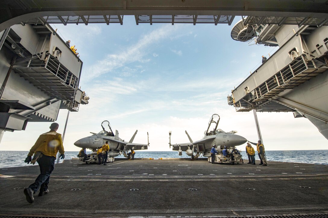 Sailors move aircraft from the flight deck to the hangar bay of the aircraft carrier USS Dwight D. Eisenhower in the the Atlantic Ocean, March 18, 2016. The Eisenhower is training with the Eisenhower Carrier Strike Group to prepare for a future deployment. Navy photo by Petty Officer Seaman Apprentice Casey S. Trietsch