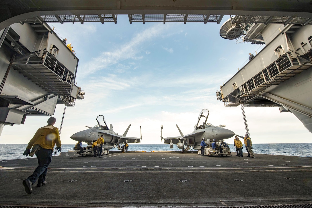 Sailors move aircraft from the flight deck to the hangar bay of the aircraft carrier USS Dwight D. Eisenhower in the the Atlantic Ocean, March 18, 2016. The Eisenhower is training with the Eisenhower Carrier Strike Group to prepare for a future deployment. Navy photo by Petty Officer Seaman Apprentice Casey S. Trietsch