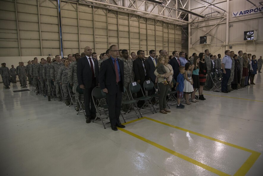 U.S. Air Force Airmen stand at attention as the national anthem plays during a ceremony, March 22, 2016, at Moody Air Force Base, Ga. The Air Force Office of Special Investigations honored two members of the 824th Base Defense Squadron by naming them honorary AFOSI special agents. (U.S. Air Force photo by Airman 1st Class Janiqua P. Robinson/Released)