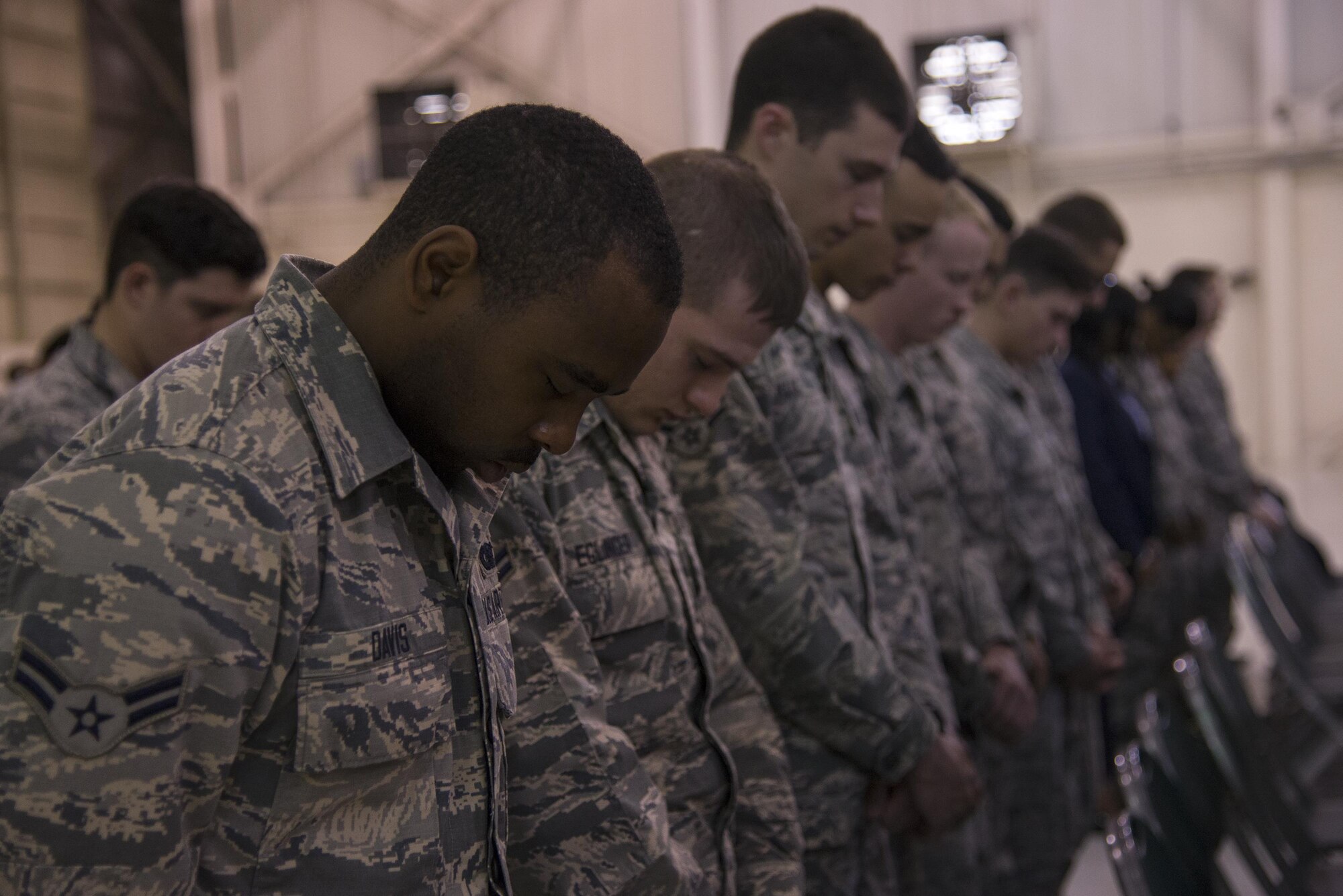 U.S. Air Force Airmen from the 820th Base Defense Group bow their heads in prayer during an invocation at a ceremony, March 22, 2016, at Moody Air Force Base, Ga. During the Air Force Office of Special Investigation’s 68-year history, less than 60 individuals have been deemed honorary special agents and, until now, none of them have been defenders. (U.S. Air Force photo by Airman 1st Class Janiqua P. Robinson/Released)
