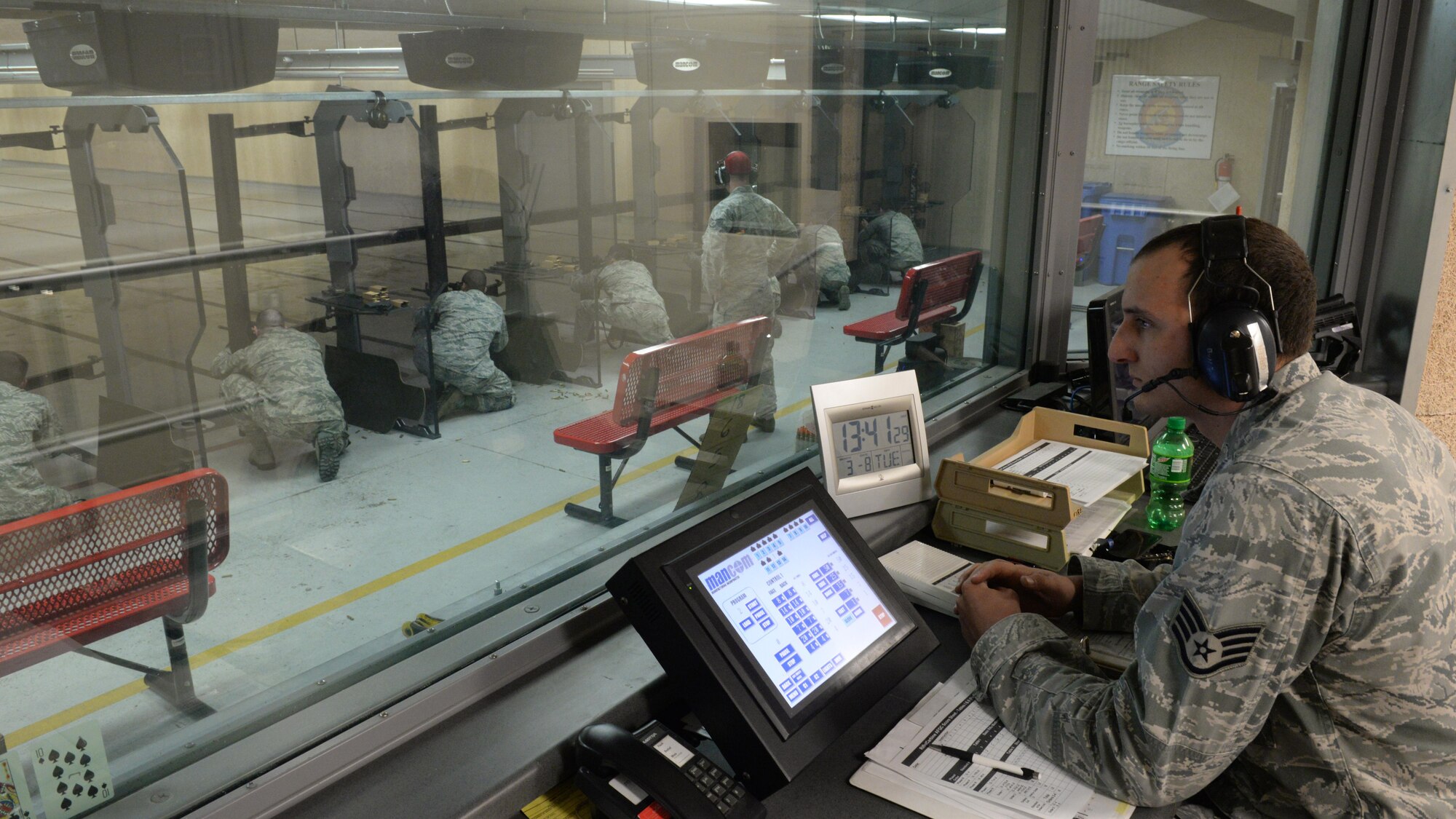 Staff Sgt. Joshua Green, 81st Security Forces Squadron combat arms instructor, supervises shooters from the control room at the Combat Arms Training and Maintenance building March 9, 2016, Keesler Air Force Base, Miss. The control room operator is in charge of telling the shooters which firing position to take, how many rounds will be shot and which target to shoot at. (U.S. Air Force photo by Airman 1st Class Travis Beihl)