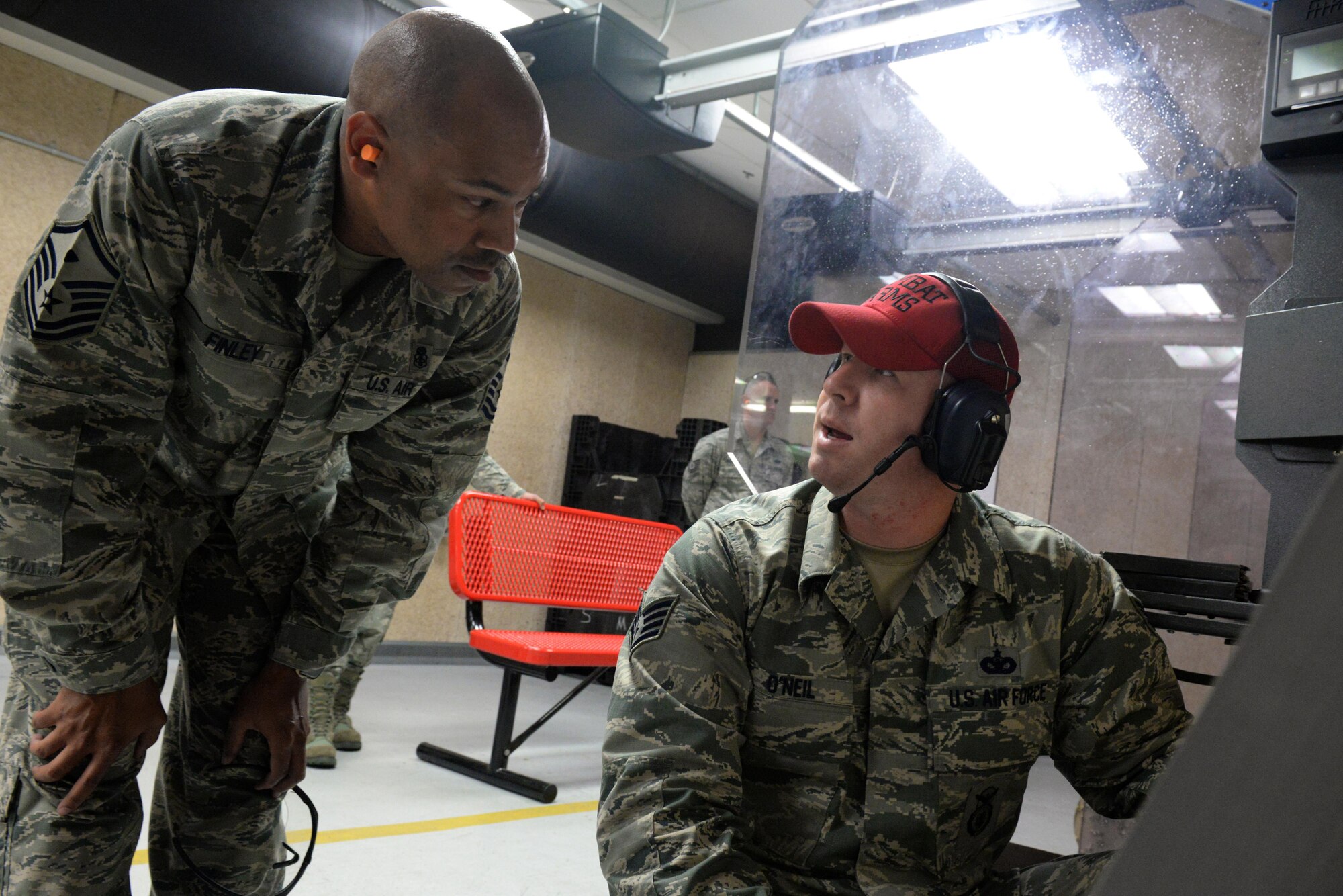 Staff Sgt. Michael O’Neil, 81st Security Forces Squadron combat arms instructor, gives feedback to Master Sgt. Leslie Finley, 81st Logistics Readiness Squadron first sergeant, following a live fire qualification session at the Combat Arms Training and Maintenance building March 9, 2016, Keesler Air Force Base, Miss. CATM instructors are in charge of student safety throughout the course and correcting shooters after all live fire has stopped. (U.S. Air Force photo by Airman 1st Class Travis Beihl)