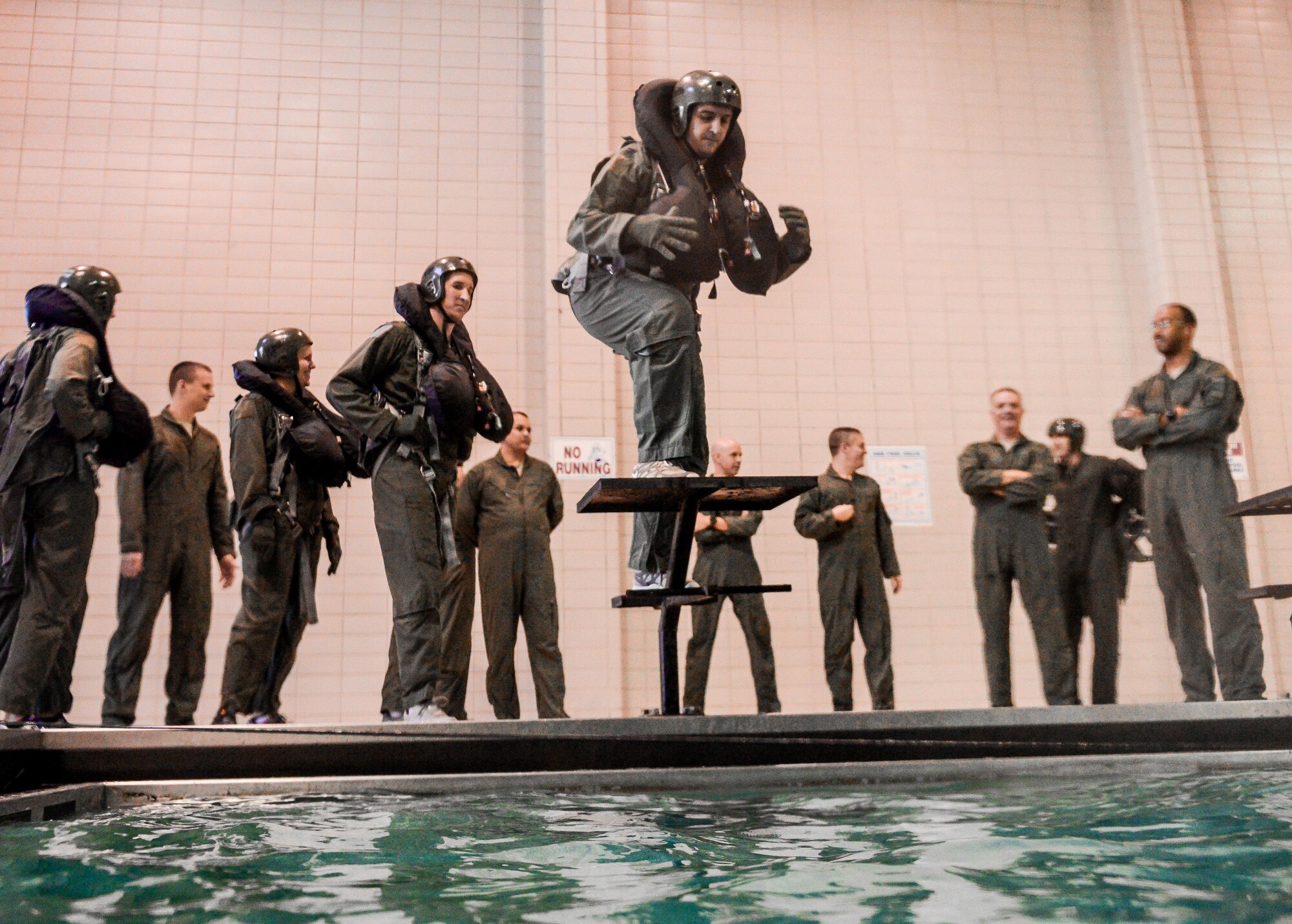 An aircrew member prepares to jump into a pool during a Survival, Evasion, Resistance and Escape water survival class in Shreveport, La., March 15, 2016. The class provided aircrew an opportunity to practice using safety equipment crucial to survival in case of aircraft ejection over a body of water. (U.S. Air Force photo/Senior Airman Mozer O. Da Cunha)