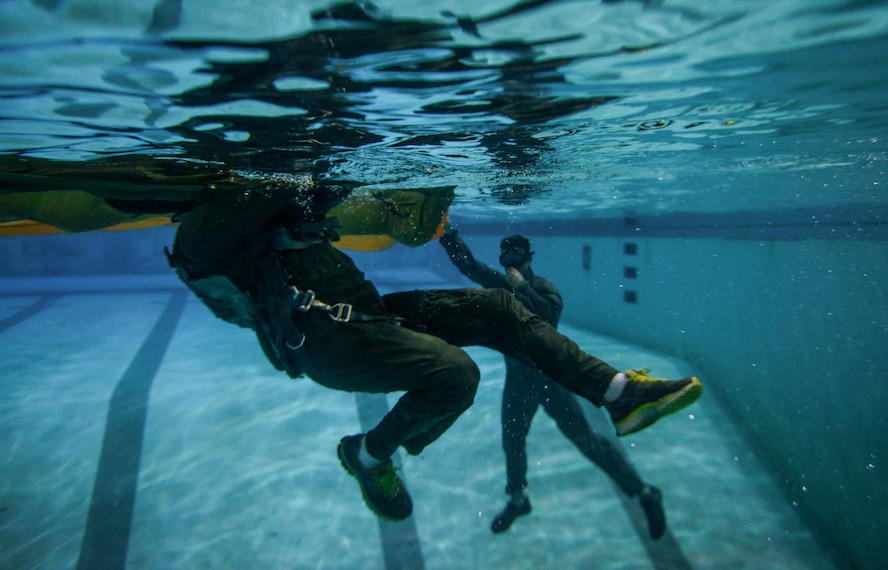 Staff Sgt. Matthew Mete, 2nd Operations Support Squadron Survival, Evasion, Resistance and Escape specialist, oversees an aircrew member evading a parachute canopy during a water survival class in Shreveport, La., March 15, 2016. Aircrew were taught to keep calm and focused in order to escape the parachute. After a successful ejection, evading the parachute in a water landing scenario is the most crucial step to increase survivability. (U.S. Air Force photo/Senior Airman Mozer O. Da Cunha)