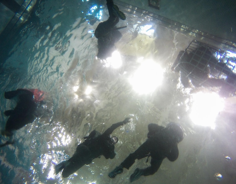 Aircrew members reach for rescue devices during a Survival, Evasion, Resistance and Escape water survival class in Shreveport, La., March 15, 2016. Aircrew learned how to use a variety of rescue devices such as life rafts, rescue baskets and forest penetrators in addition to improvised rope hoist techniques used for extraction. (U.S. Air Force photo/Airman 1st Class Luke Hill)