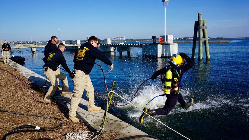 Sgt. Kyle Bradley, a salvage diver from the 511 Engineer Dive Detachment, jumps into water to perform underwater cutting at the Morehead City, N.C., Reserve Center pier. The active duty unit removed a dozen 10,000 pound pilings at the reserve center as part of a Troop Construction project, saving the Army money while performing real world training.