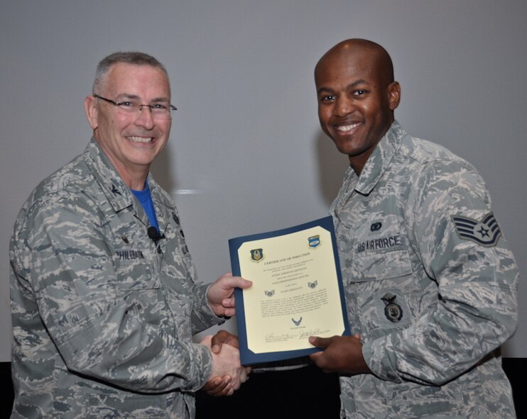 Commander of the 932nd Airlift Wing, Col. Jonathan Philebaum, called Staff Sgt. Avery Grinston up before the unit at a recent ceremony to present this certification of induction, recognizing the sergeant as a noncommissioned officer in the Air Force Reserve Command. (U.S. Air Force photo by Staff Sgt. Amber Hodges)