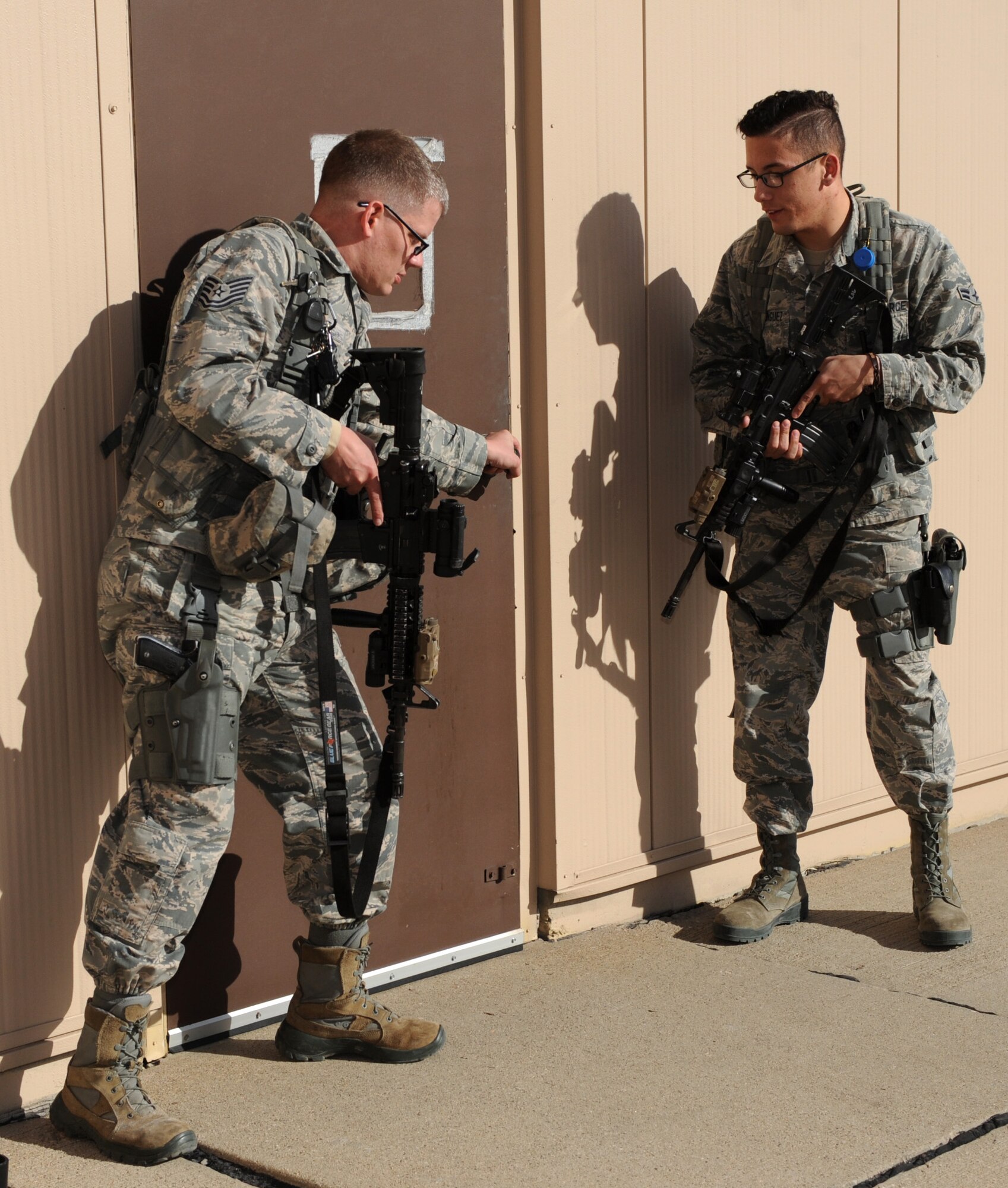 Tech. Sgt. Steven Groff, 28th Security Forces Squadron flight chief, and Airman 1st Class Christopher Dominguez, 28th SFS response force member, prepare to search a building on the flightline during a training exercise at Ellsworth Air Force Base, S.D., Feb. 10, 2016. Defenders must be ready at a moment’s notice for any situation that may occur, whether it be a drunken driver or an active shooter. (U.S. Air Force photo by Airman 1st Class Denise M. Nevins/Released)