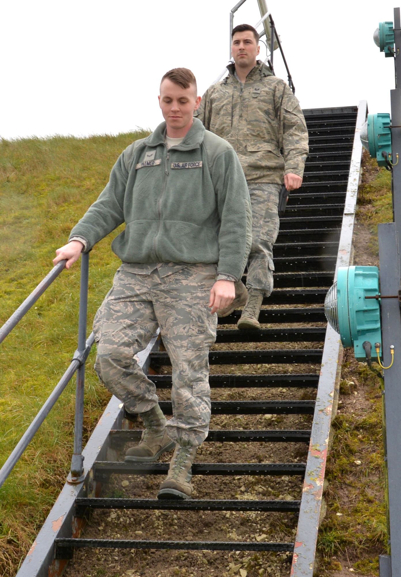 U.S. Air Force Airman 1st Class George Palmer, front, 100th Logistics Readiness Squadron mobile distribution operator, and U.S. Air Force Staff Sgt. Dakota Ferris, 100th LRS NCO in charge of fixed facilities, descend from a partial underground fuel tank March 9, 2016, on RAF Mildenhall, England. Fuels Airmen are in charge of ensuring the facilities are inspected daily and ready to operate at their full capability. (U.S. Air Force photo by Gina Randall/Released)