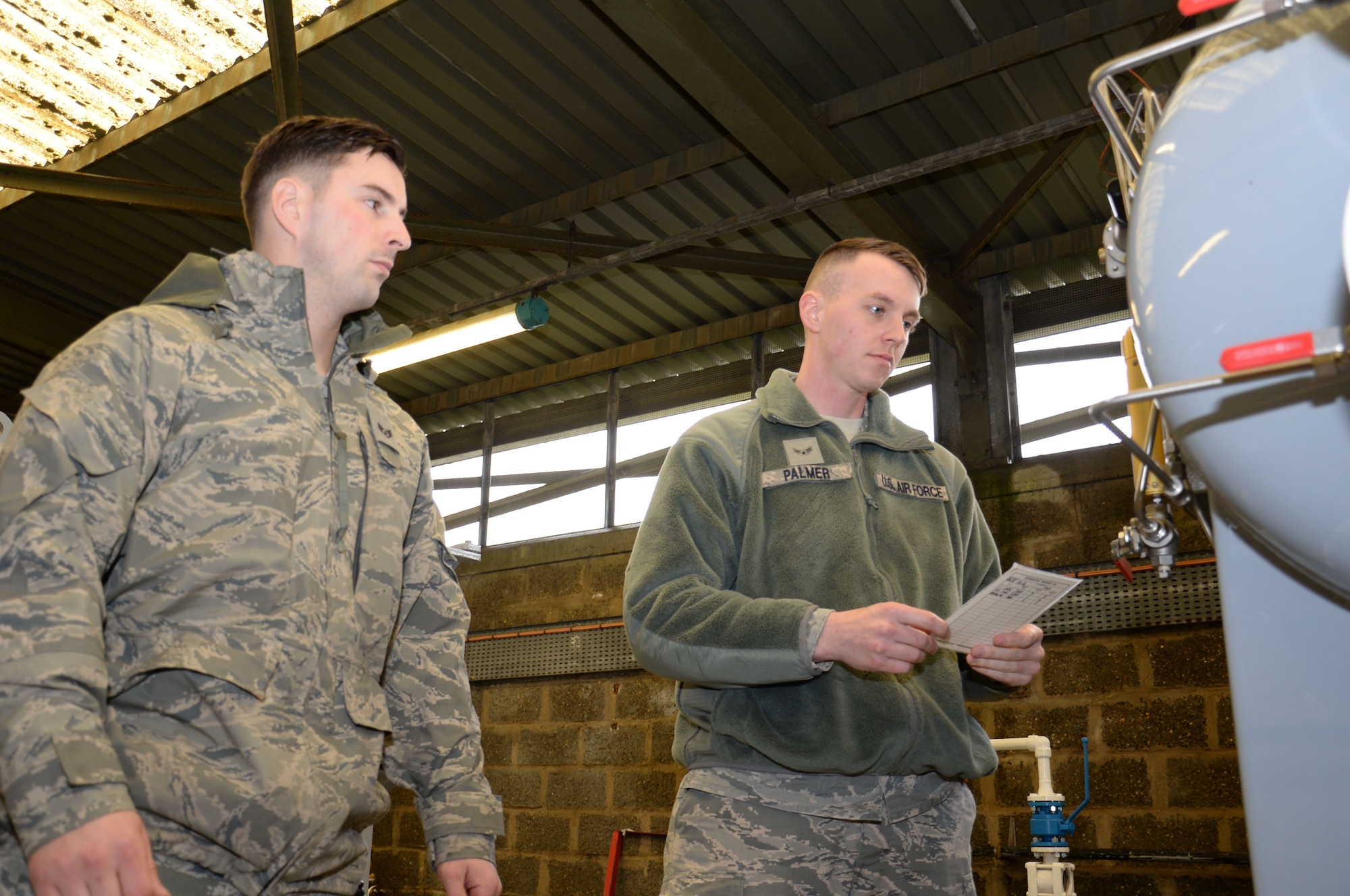 U.S. Air Force Airman 1st Class George Palmer, right, 100th Logistics Readiness Squadron mobile distribution operator, and U.S. Air Force Staff Sgt. Dakota Ferris, 100th LRS NCO in charge of fixed facilities, check differential pressure of the fuel filter separator March 9, 2016, on RAF Mildenhall, England. The Airmen verify the filter separators are working properly to ensure only clean, sediment and water free fuel, is issued to the aircraft. (U.S. Air Force photo by Gina Randall/Released)