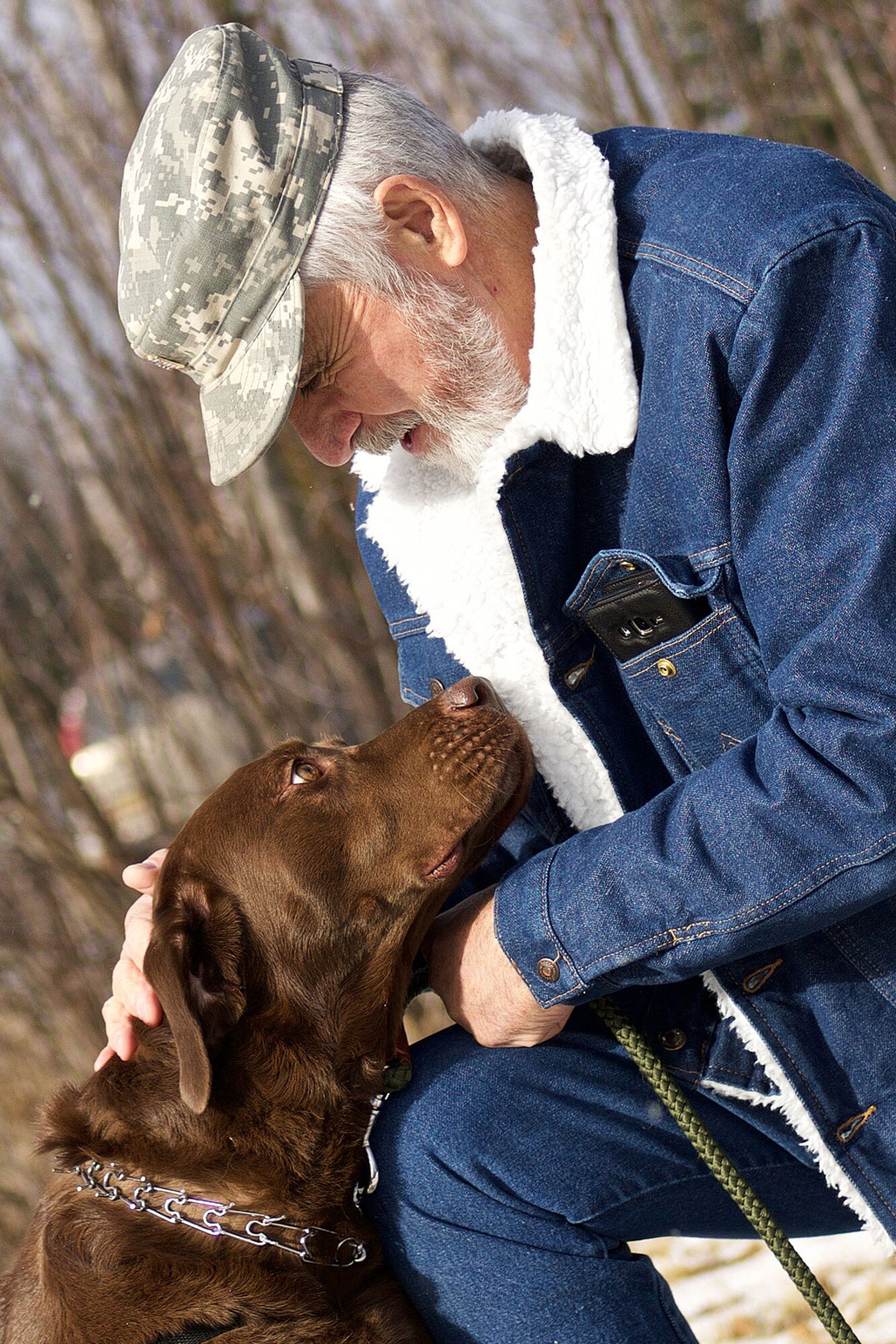 Ken Bylo, an Army veteran who served in Vietnam during the Tet Offensive, plays with his new service dog, Cowboy. Cowboy was given to him by a nonprofit organization after losing his previous service dog. During his time in Vietnam, Bylow earned a Bronze Star Medal with V for Valor. (U.S. Air Force photo by David Bedard)