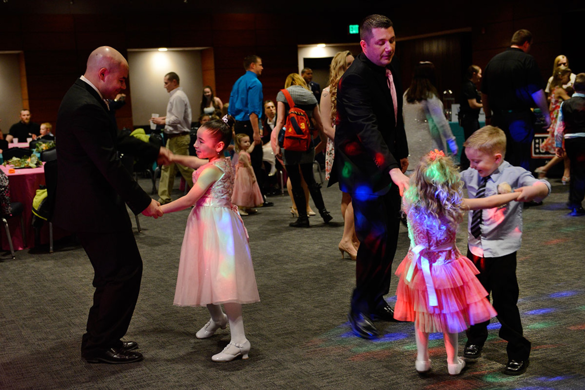 Parents dance with their children during the Father/Daughter and Mother/Son Dance at the Arctic Warrior Events Center March 18, 2016. The formal dance was a way for parents to spend personal time with their children. (U.S. Air Force photo by Airman Valerie Monroy)